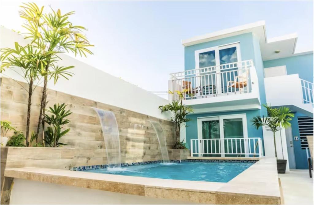 a villa with a swimming pool and a house at Breeze Point at Ocean in San Juan