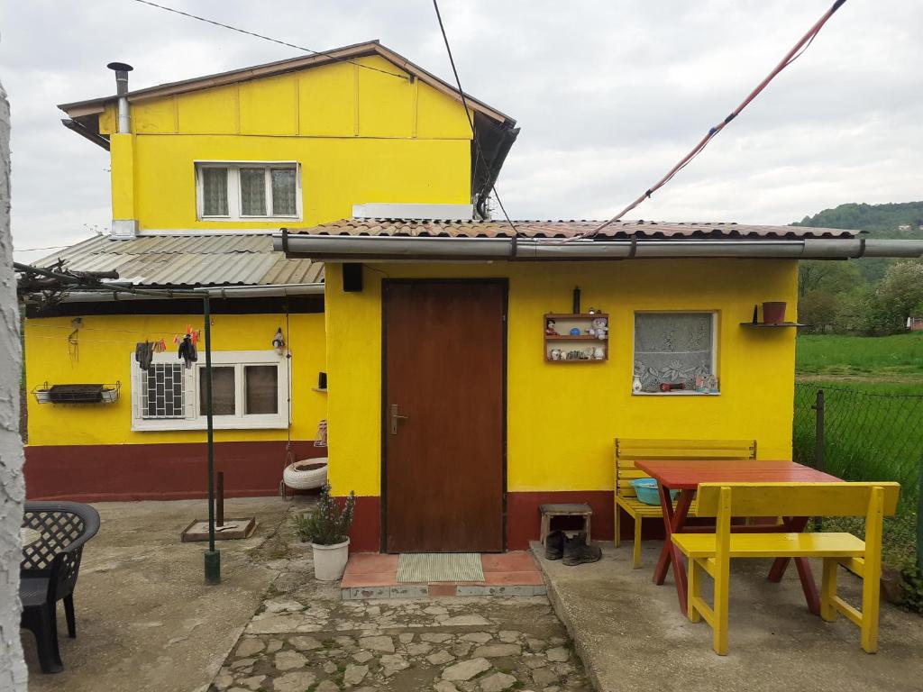 una casa amarilla con una mesa delante en Yellow fairy tale, en Visoko