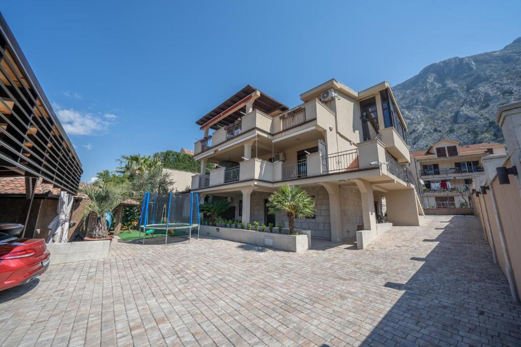 a large house with a driveway in front of it at Apartments Milunović in Kotor
