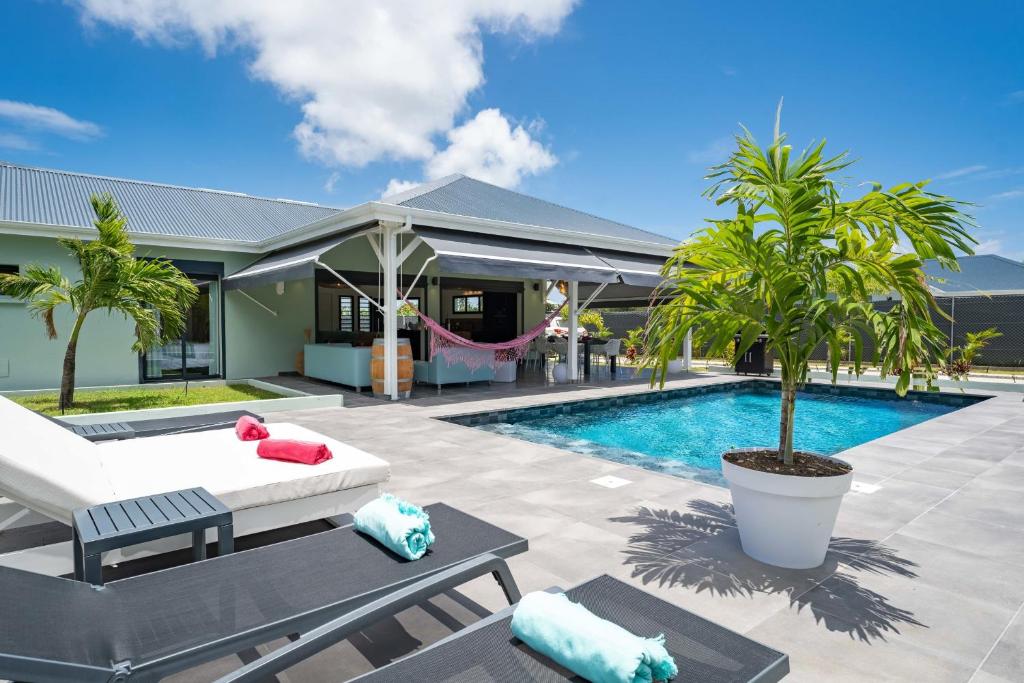 eine Villa mit Swimmingpool und einem Haus in der Unterkunft Villa Faustine in Saint-François
