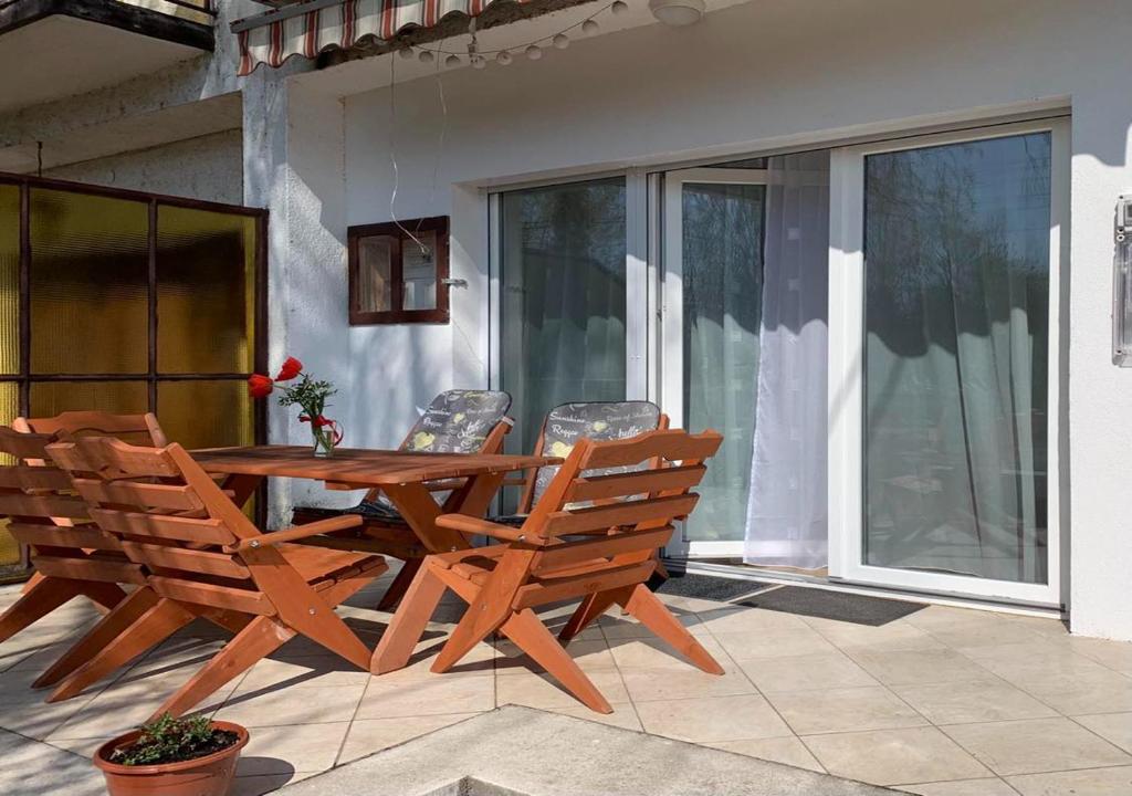 drewniany stół i krzesła na patio w obiekcie Portum vendégház w Siófoku