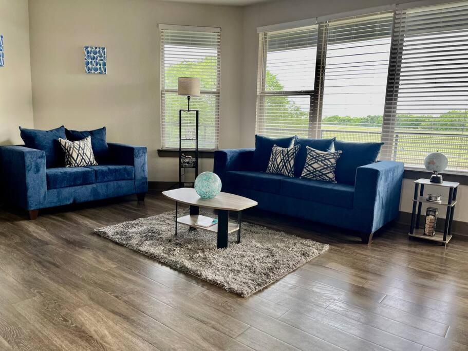 una sala de estar con sofás azules y una mesa. en Elegant 2 for 2 en Houston