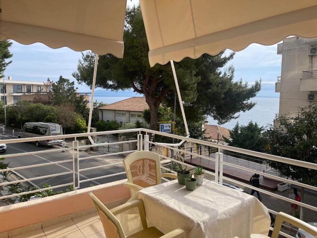 a table and chairs on a balcony with a view of a street at Saranda Aquamarine Sea View Condo in Sarandë