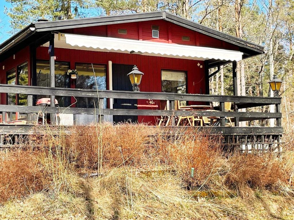 una cabina roja en medio de un campo en Holiday home NORRTÄLJE IV, en Norrtälje