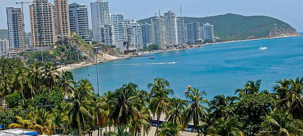 a view of a beach with palm trees and buildings at Apartamento Vista azul rodadero Laureles 801 in Rodadero