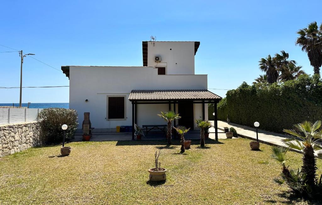 uma casa branca com plantas num quintal em Il Frantoio di Avola em Avola