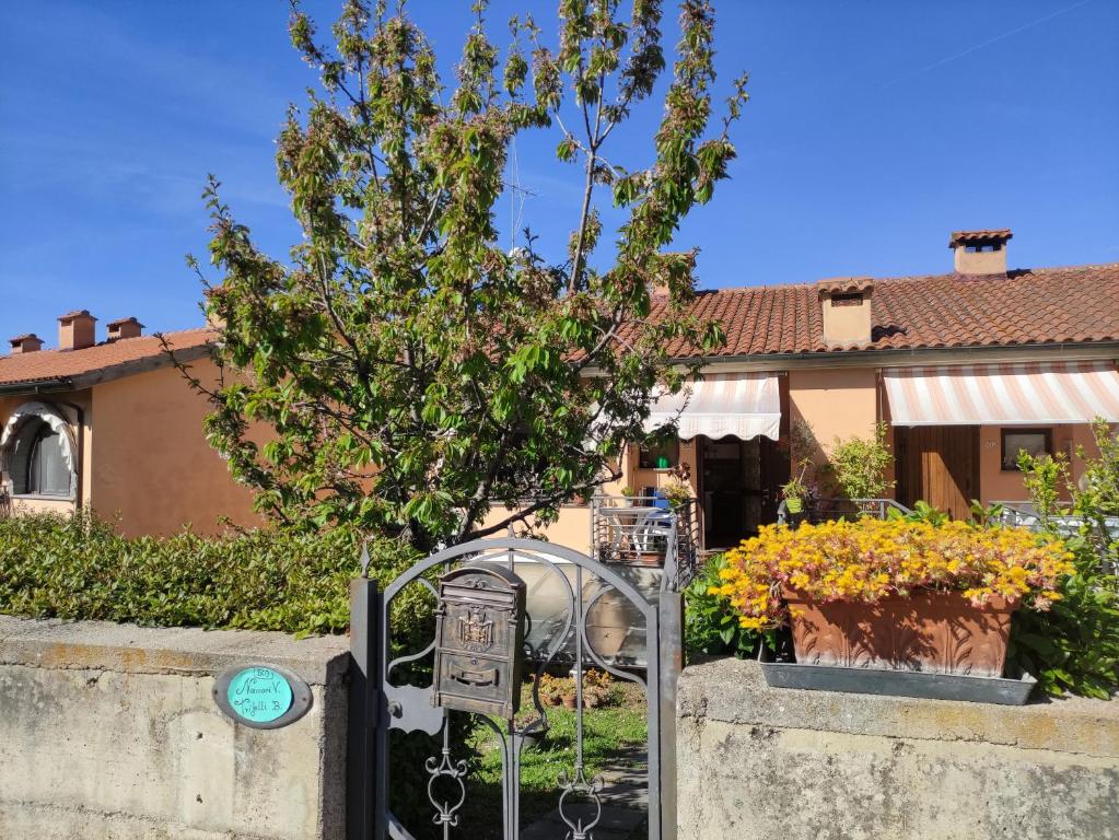 a gate in front of a house with a tree at B & V HOME in Montemerano