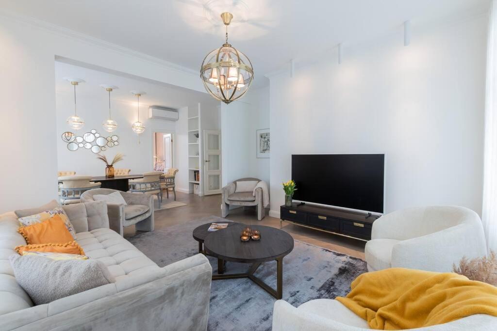 Il comprend un salon doté d'un mobilier blanc et d'une télévision à écran plat. dans l'établissement Luxury Villa, à Pärnu
