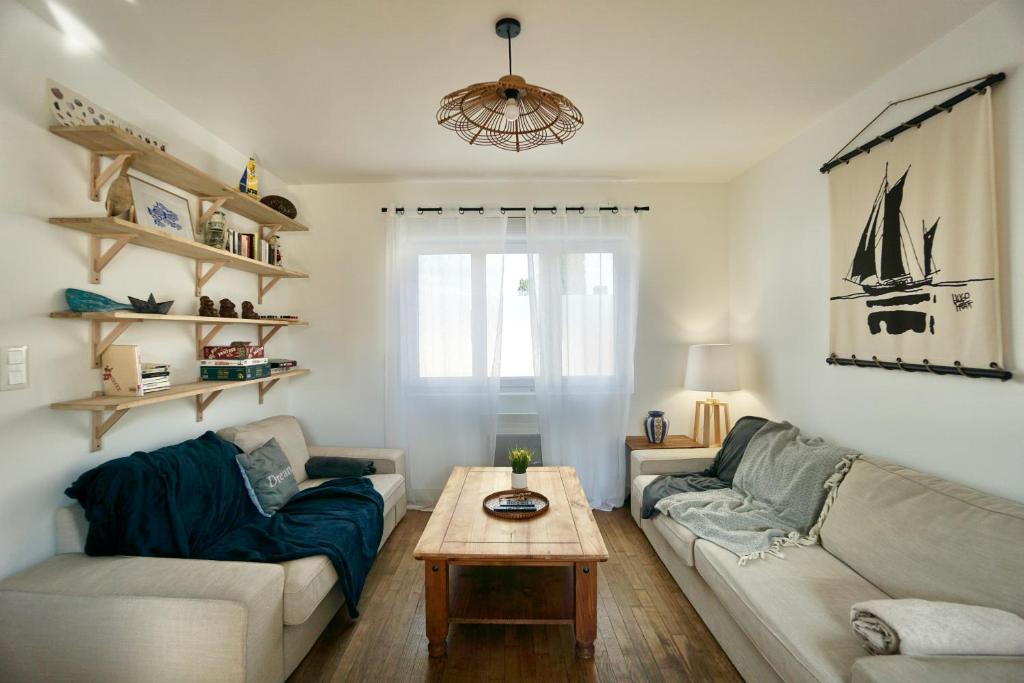 ein Wohnzimmer mit einem Sofa und einem Tisch in der Unterkunft Le Logis de la Mer in Concarneau