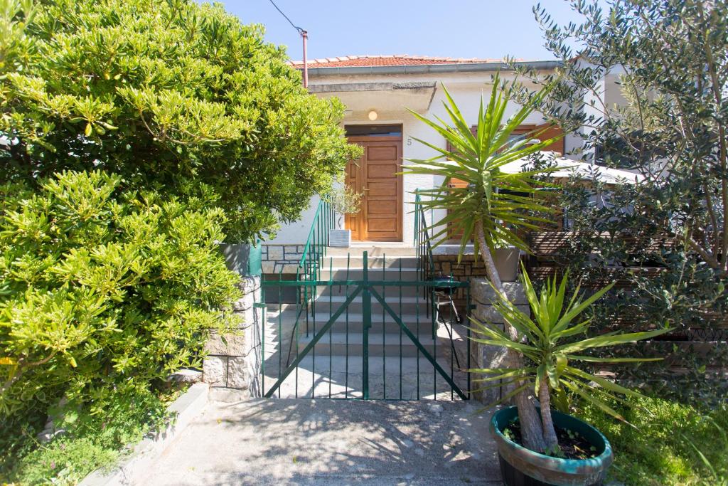 a house with a gate and two palm trees at Holiday house VIDA in Biograd na Moru