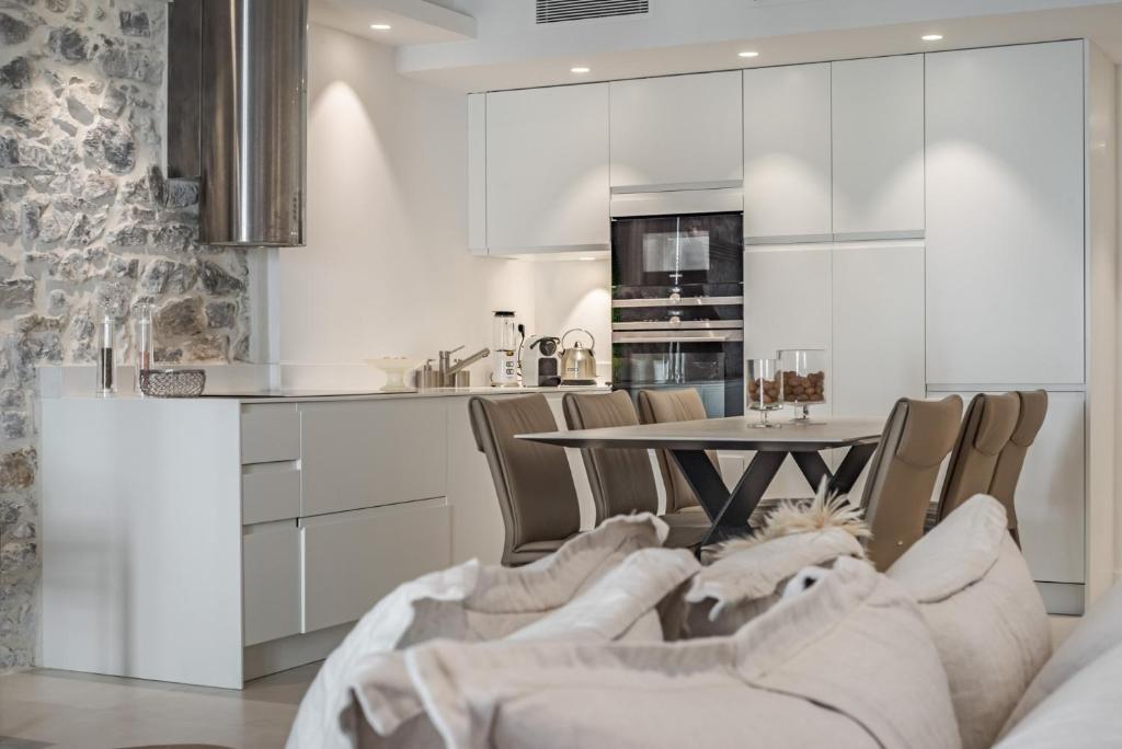 a kitchen with white cabinets and a table and chairs at Paula by Terry&#39;s Homes in Cannes