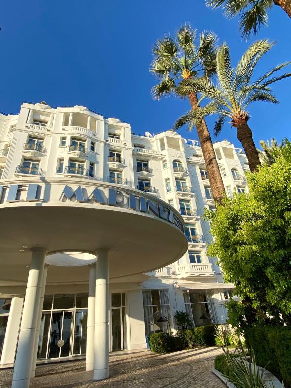 a large white building with a palm tree in front of it at Paula by Terry&#39;s Homes in Cannes