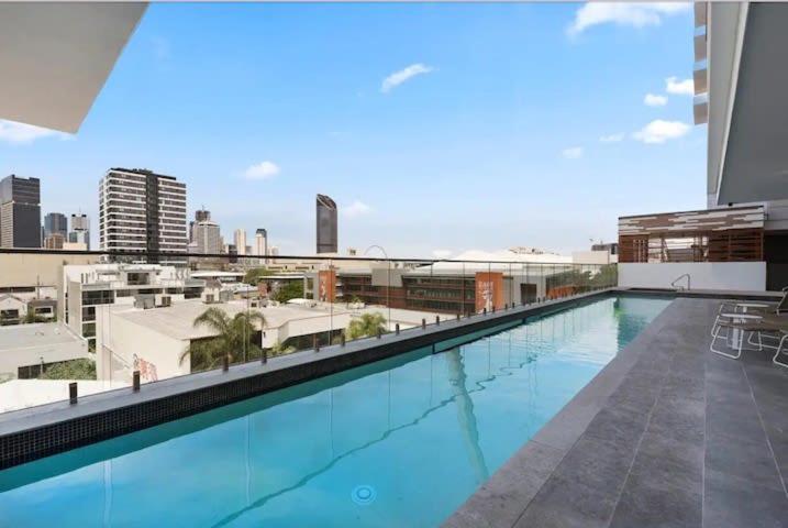 a large swimming pool on top of a building at Cosy and Stylish 1 BD Serviced Apt at SouthBank in Brisbane
