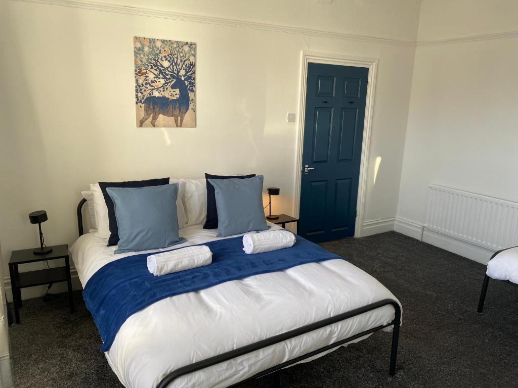 1 dormitorio con 1 cama grande con almohadas azules en Overhill - Spacious 2 bed ground floor flat close to Newcastle, en Gateshead