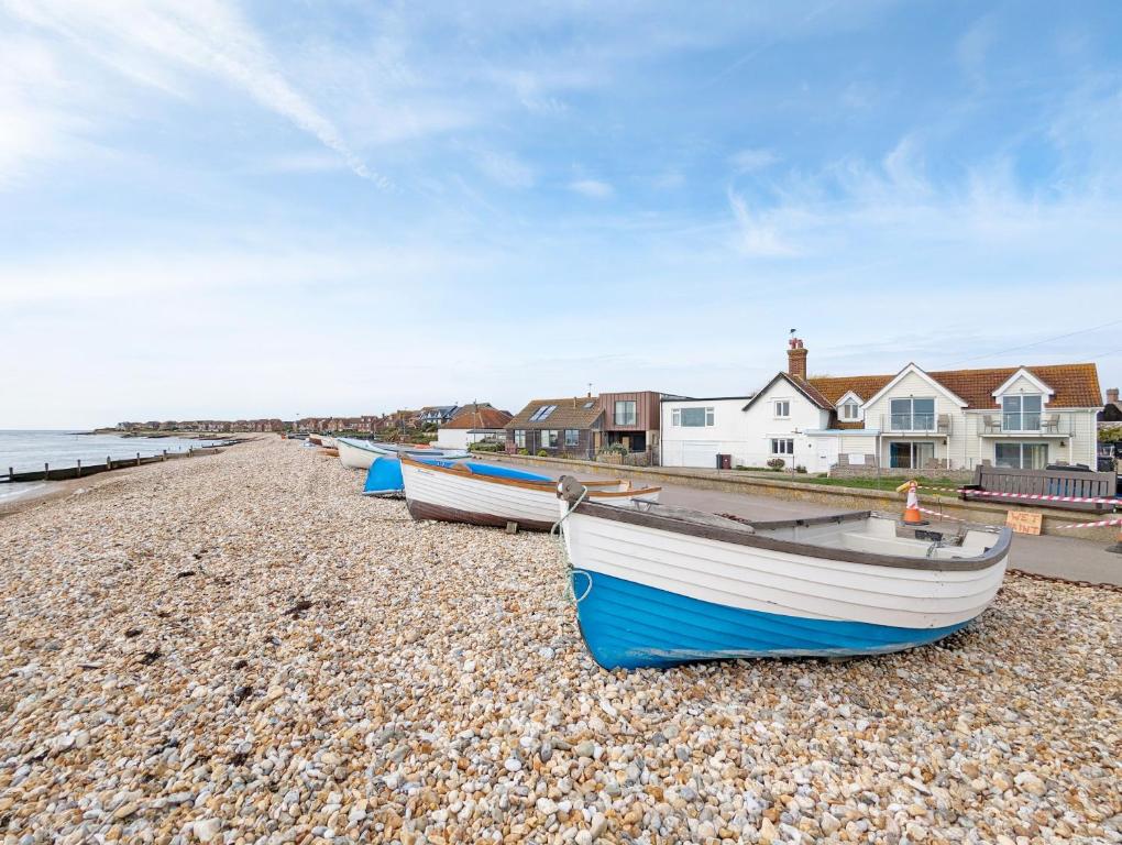 a group of boats sitting on a rocky beach at Seaside in Selsey