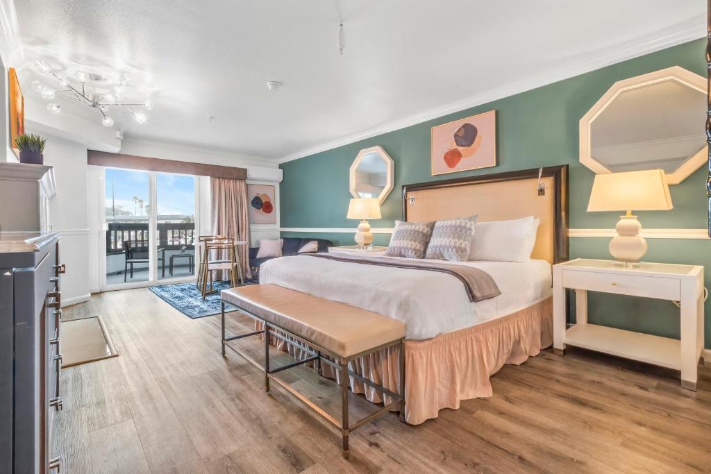 ein Schlafzimmer mit einem großen Bett und einem Balkon in der Unterkunft Ascot Suites Morro Bay in Morro Bay