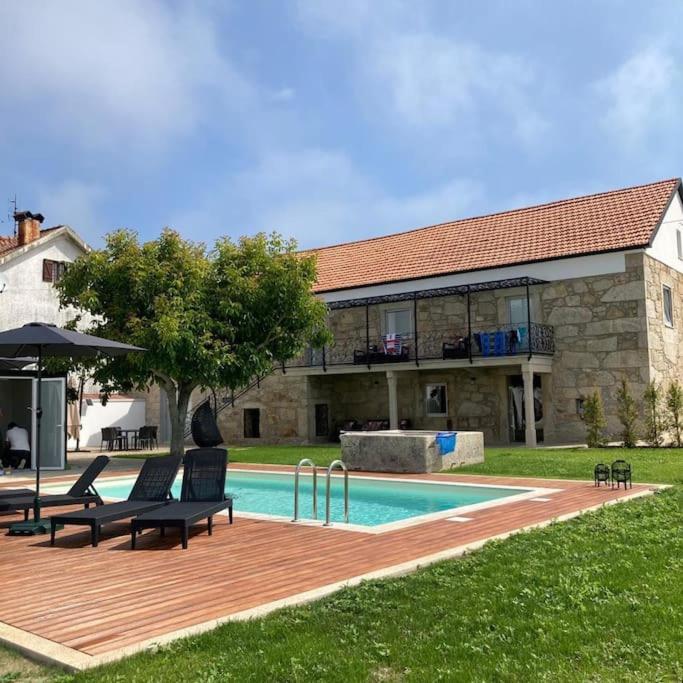 a swimming pool with two chairs and a building at Sete Azenhas in Esposende