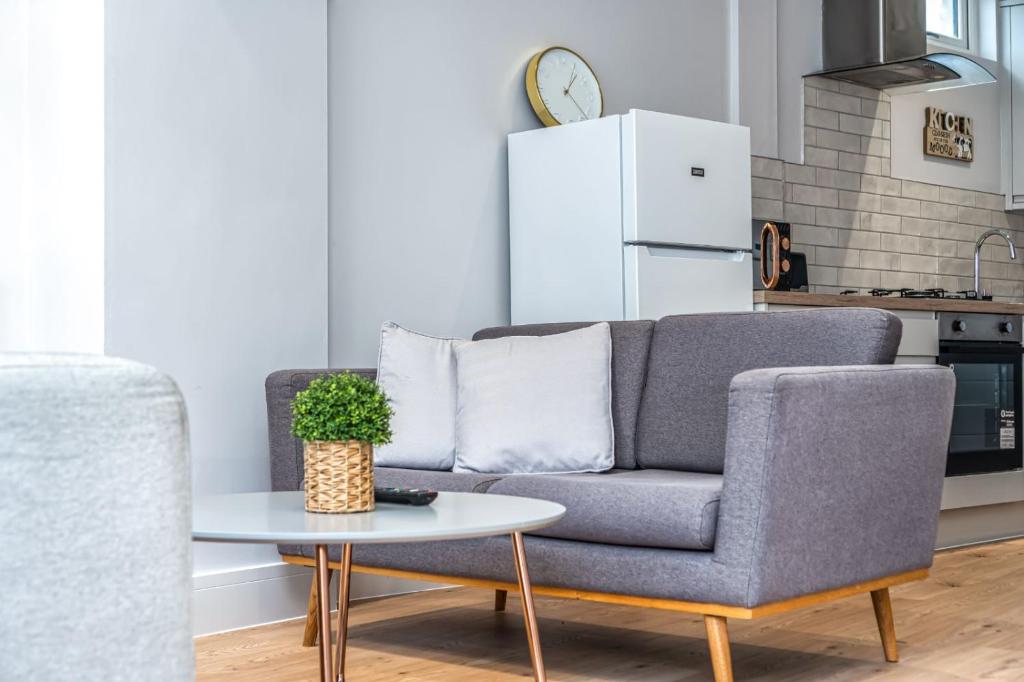 ein Wohnzimmer mit einem Sofa und einem Tisch in der Unterkunft Modern Apartment in East London in London