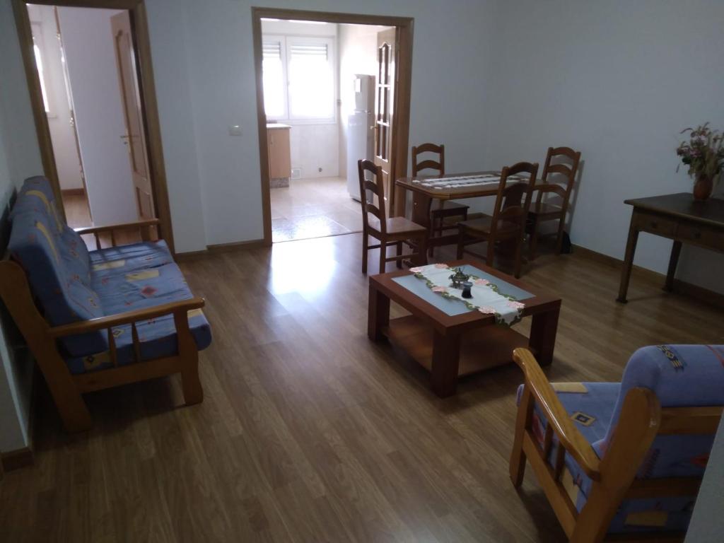 a living room with wooden chairs and a table and chairs at Ático Rosita en Camino de Santiago in Xinzo de Limia