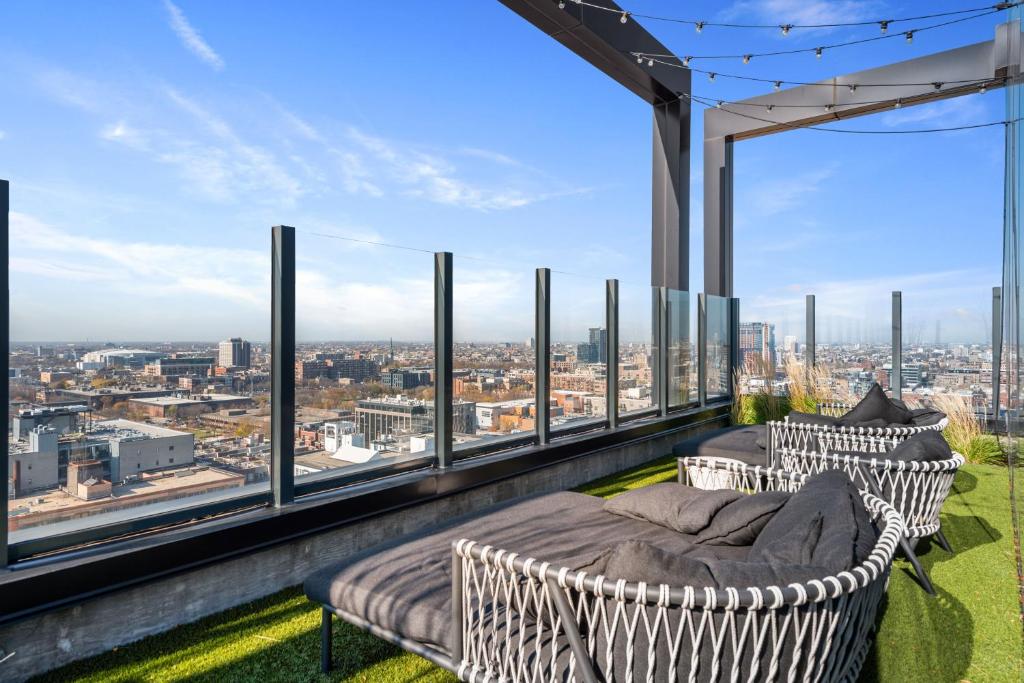 a balcony with two chairs and a view of the city at Avra Stylish Apartments Prime West Loop Location Near Union Park in Chicago