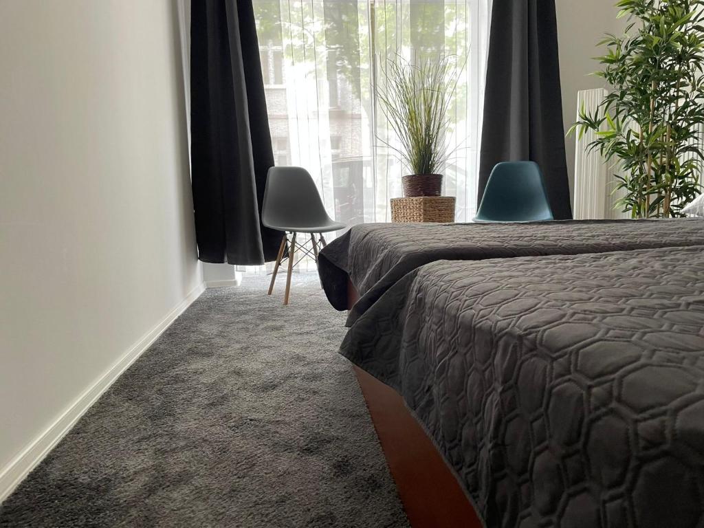 ベルリンにあるBerlinhome Apartment Köpenickのベッドルーム1室(ベッド1台付)、植物のある窓が備わります。
