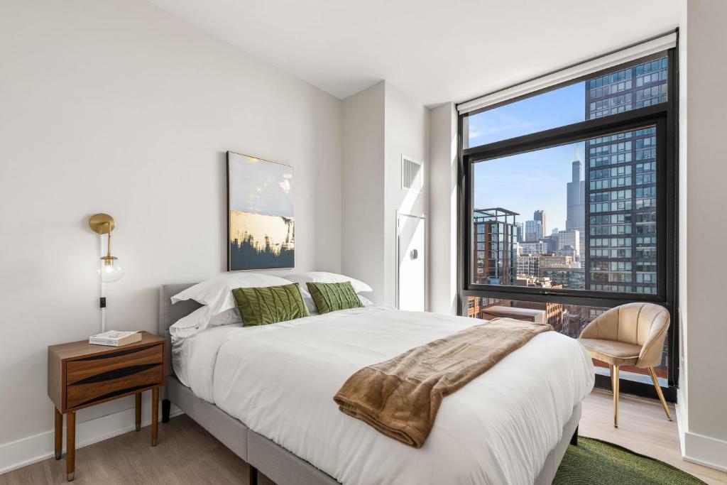 a bedroom with a large bed and a large window at Avra Stylish Apartments Prime West Loop Location Near Union Park in Chicago