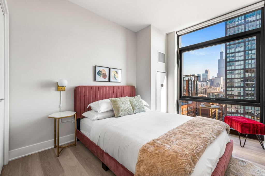 a bedroom with a bed and a large window at Avra Stylish Apartments Prime West Loop Location Near Union Park in Chicago