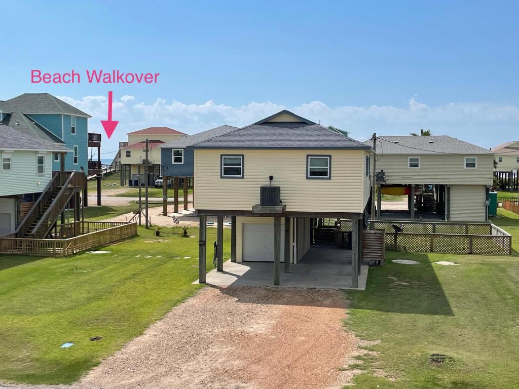 una casa con una passerella sulla spiaggia accanto a un cortile di Sunshine DayDream by SurfBreakLLC a Surfside Beach