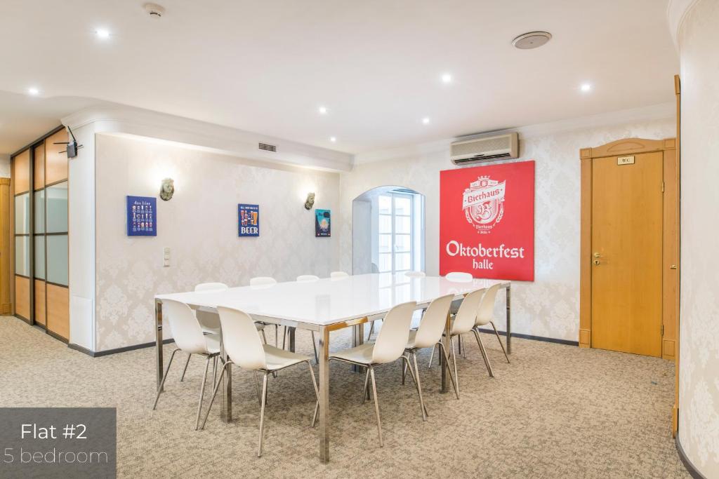 une salle de conférence avec une table et des chaises blanches dans l'établissement Dandelion Apartments Lāčplēša, à Riga