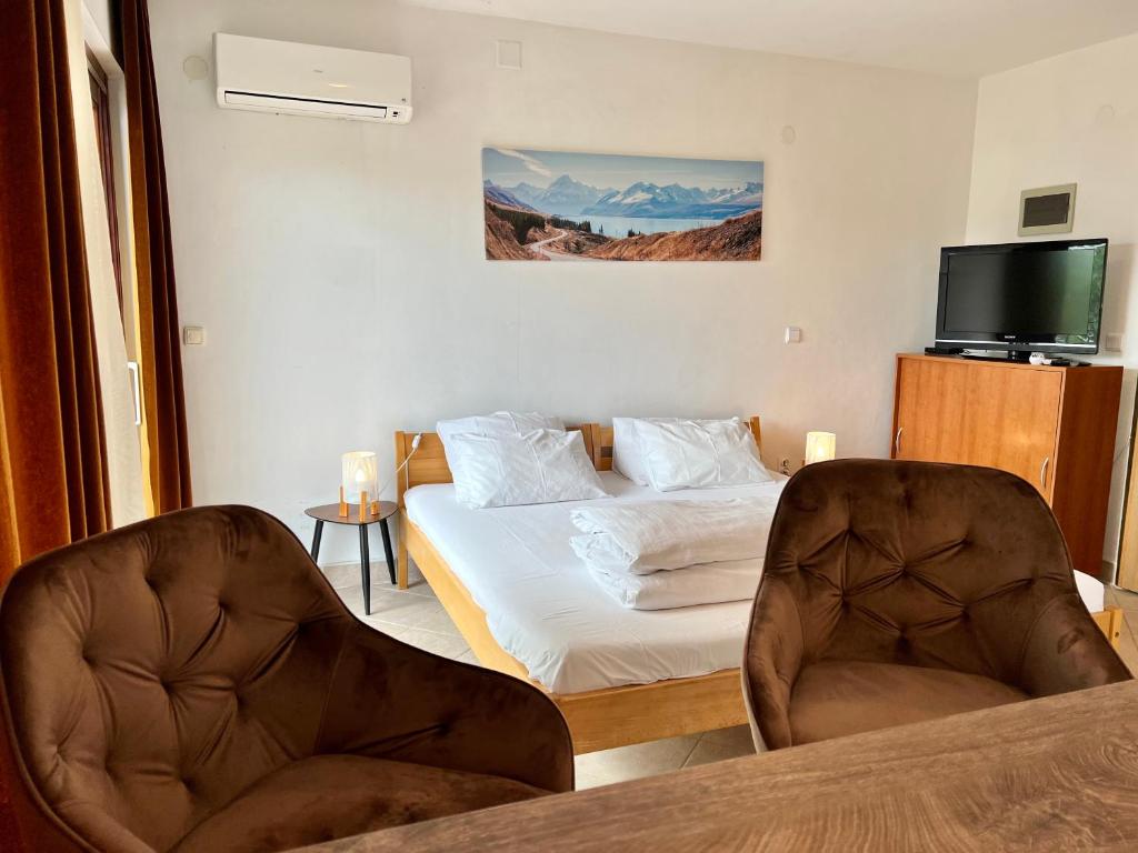 pokój hotelowy z łóżkiem i dwoma krzesłami w obiekcie Rooms & Apartment Hegic w mieście Zadar