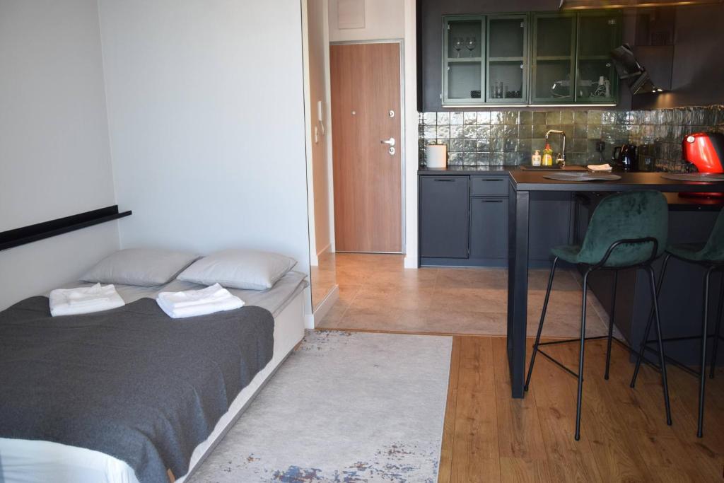 a small room with a bed and a kitchen at Studio close to city centre and airport in Gdańsk