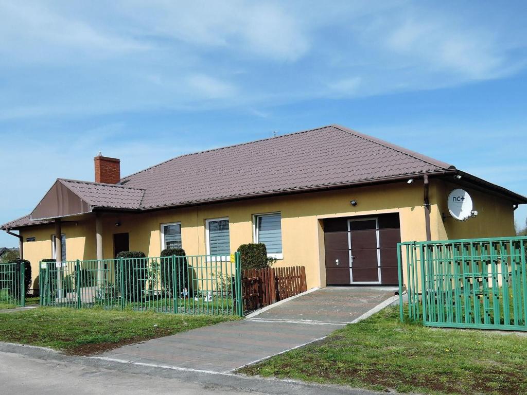 Stepnica的住宿－Holiday flat, Stepnica，前面有栅栏的黄色房子