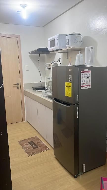 a kitchen with a black refrigerator in a room at OK kada Inn Quezon City in Manila
