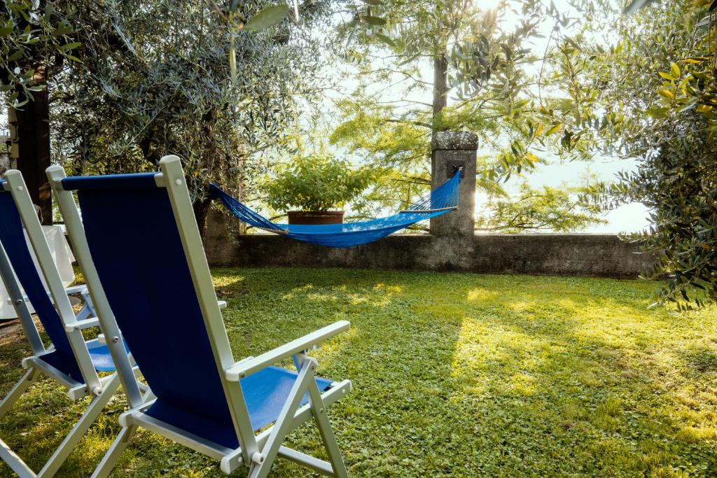 uma rede azul num quintal com duas cadeiras em Lake experience! em Marone