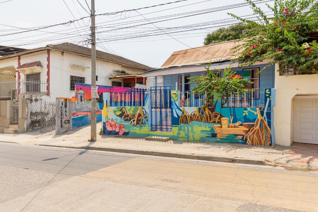 a blue building with a mural on it on a street at THE MANGO TREE HOSTEL 4:20 in Cartagena de Indias