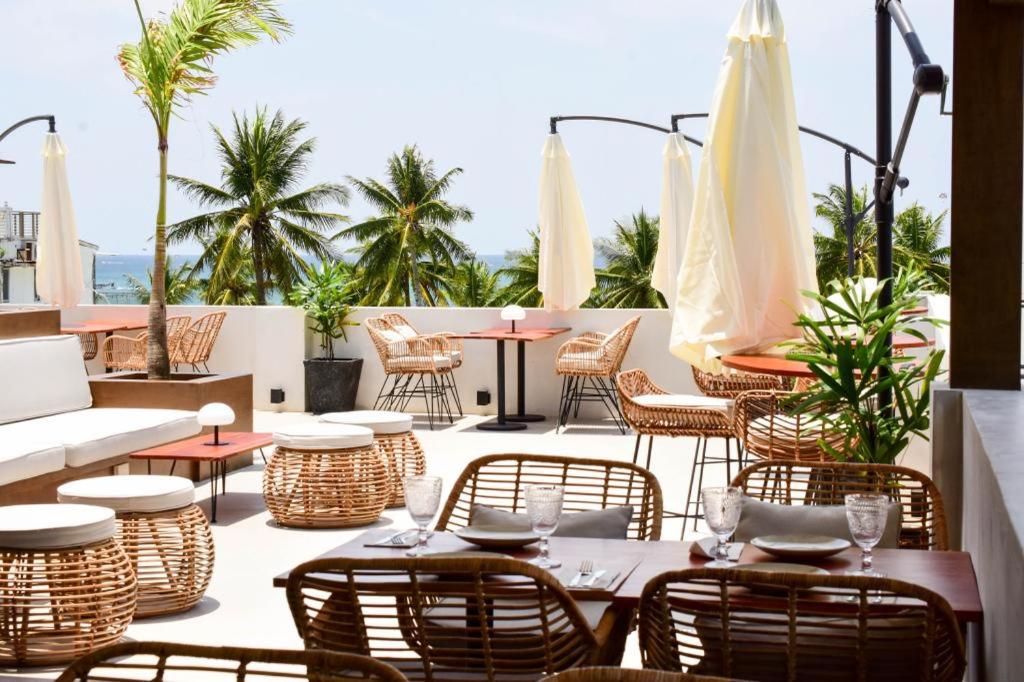 an outdoor patio with tables and chairs and umbrellas at Serene La Playa Boracay in Boracay