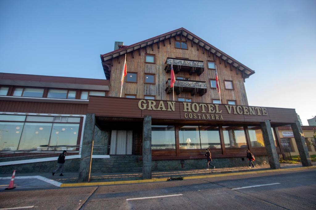 a building with people walking in front of it at Gran Hotel Vicente Costanera in Puerto Montt