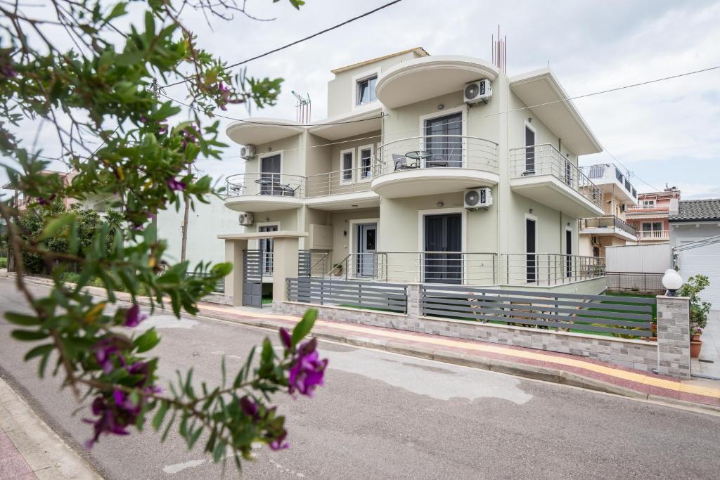 a white house with purple flowers in front of it at Vonitsa Luxury Apartments in Vonitsa