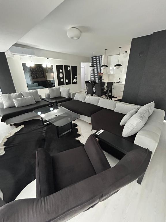 een woonkamer met banken en een eetkamer bij Sandev apartments Black&White in Štip