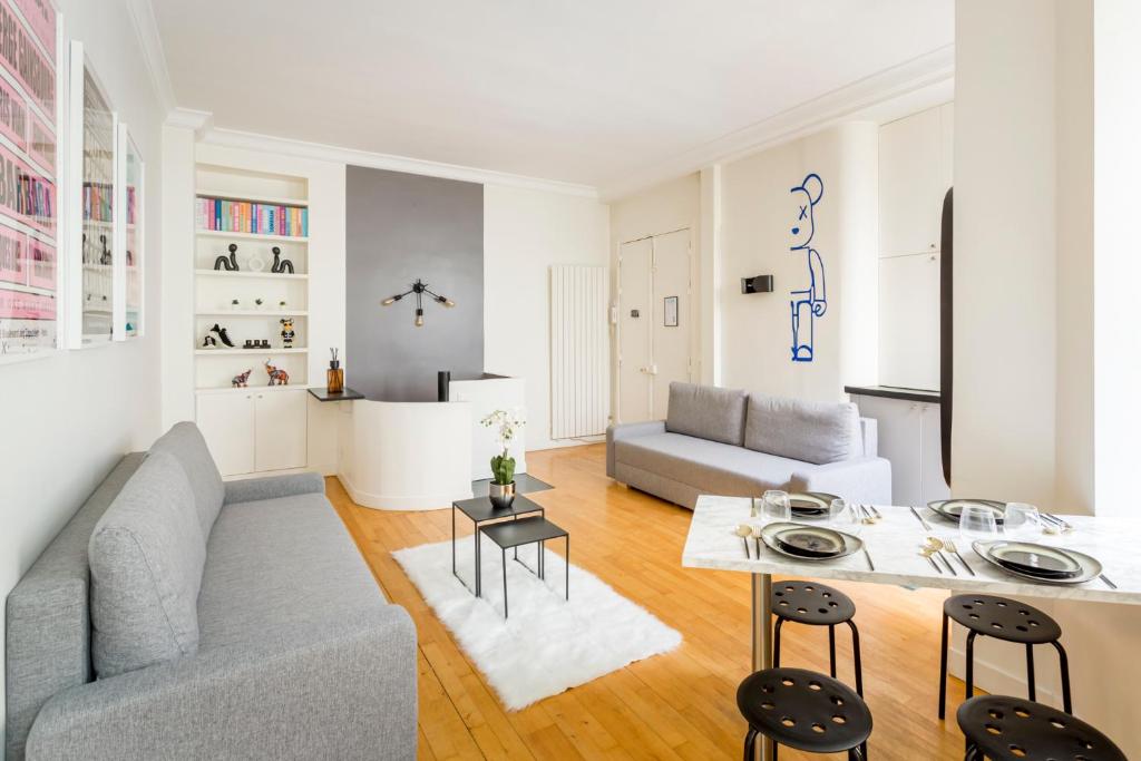 uma sala de estar com um sofá e uma mesa em SLEEPOO - Fabulous 8 em Paris