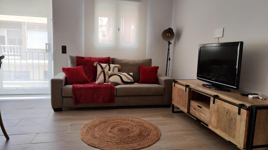 a living room with a couch and a flat screen tv at Casa FotoStudi37 in Deltebre