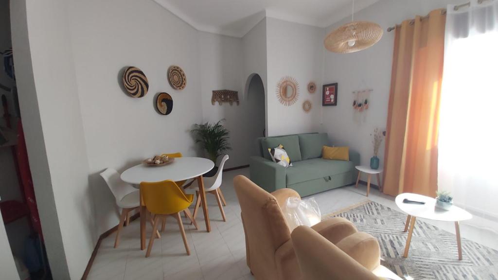 een woonkamer met een bank en een tafel en stoelen bij Ofelia Terrace House in Portimão
