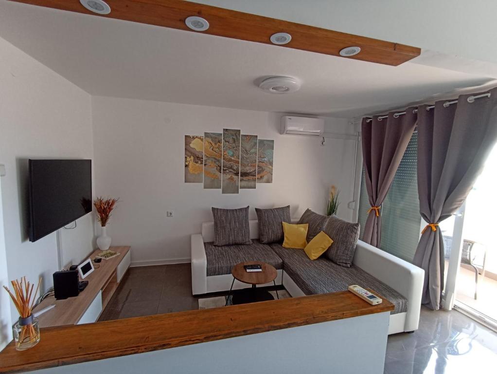 a living room with a couch and a tv at Beetlejuice Apartments in Šibenik