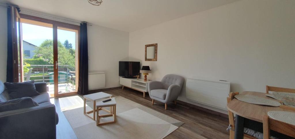 Televízia a/alebo spoločenská miestnosť v ubytovaní Duplex proche de Genève et du lac léman