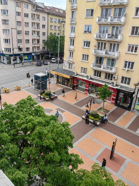 an empty street in a city with tall buildings at Vitosha 67 in Sofia