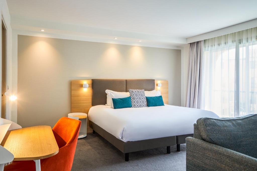 una camera d'albergo con letto e divano di Holiday Inn Perpignan, an IHG Hotel a Perpignano
