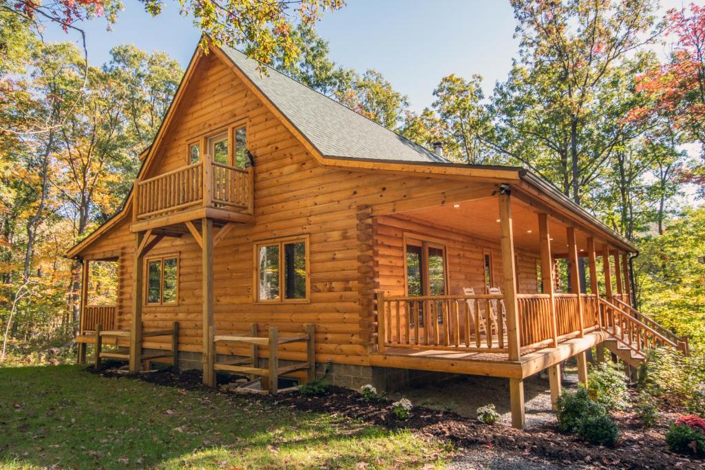 a log cabin in the woods with a large deck at Wander Inn in McHenry