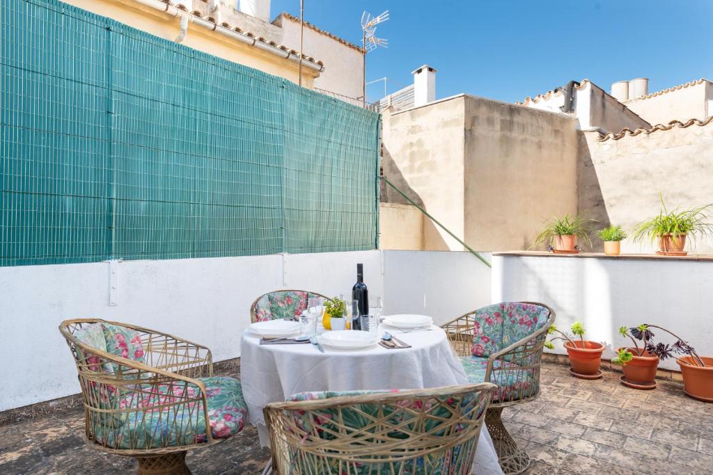 a table with chairs and a bottle of wine on a patio at Townhouse Can Bregat in Pollença