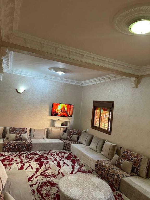 a large living room with couches and a large rug at La Casa votre hébergement idéal in Dakhla