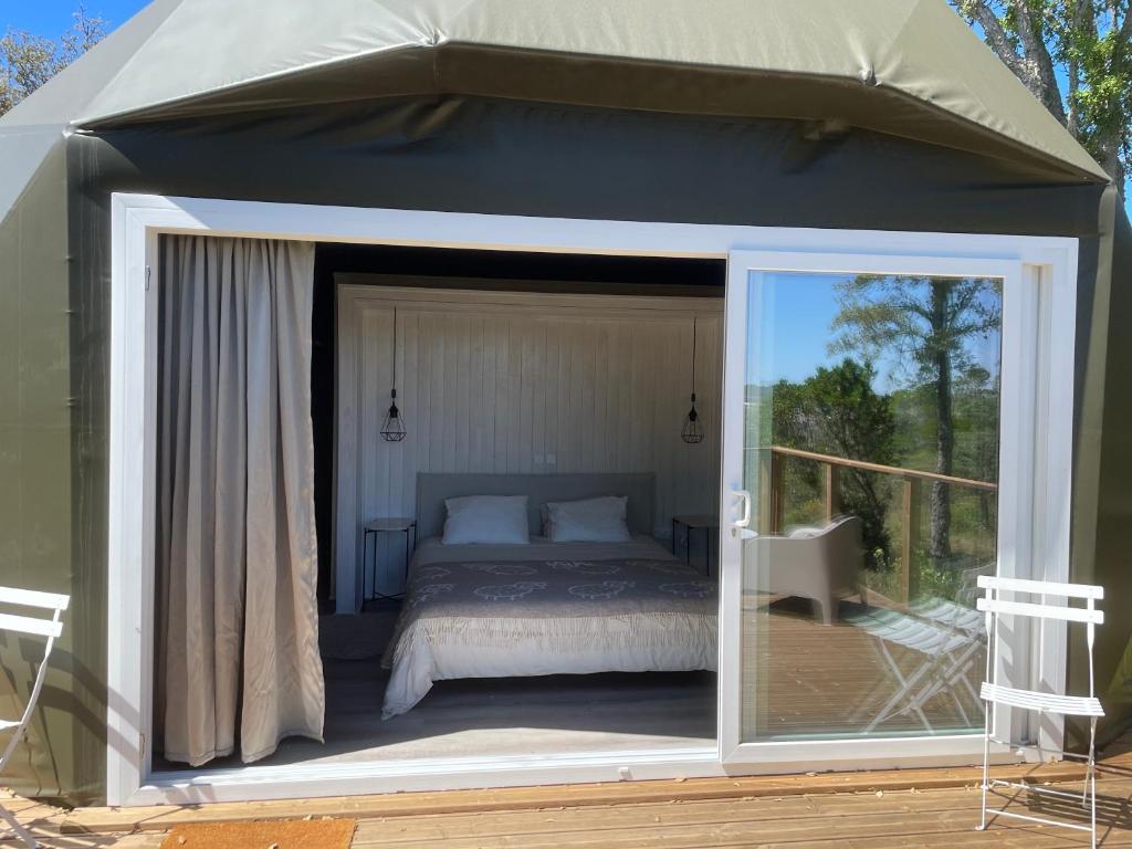 a bedroom in a tent with a bed on a deck at Nature Nest Aljezur in Aljezur